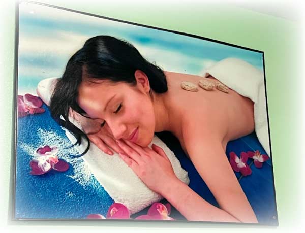 Calming wall art decor inside Golden Hands Massage shop depicting a relaxing hot stone spa experience to promote a peaceful atmosphere for customers.