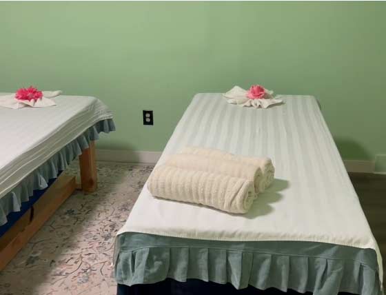 Clean and private dual massage room setup at Golden Hands Massage Fresno with fresh linens and towel art, ready for couples or friends seeking body relief.